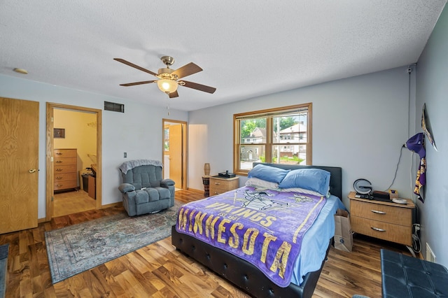2651 Colfax Ave N, Minneapolis, MN 55411 - bedroom with wood finished floors, a textured ceiling, a ceiling fan, and connected bathroom