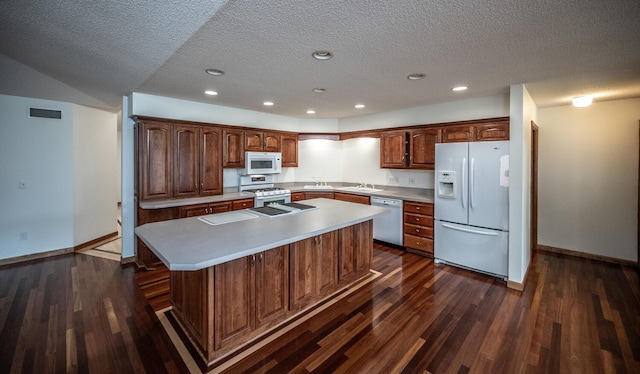 705 Grundhoefer Ct, Northfield, MN 55057 - kitchen with white appliances, a center island, dark wood-type flooring, a textured ceiling, and light countertops