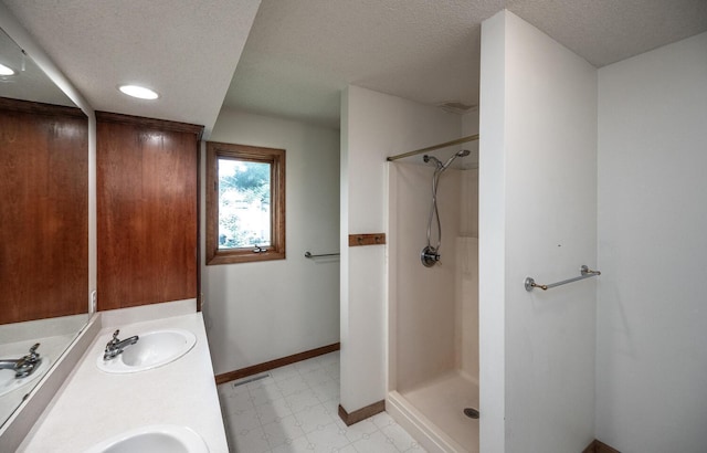 705 Grundhoefer Ct, Northfield, MN 55057 - bathroom with tile patterned floors, a shower, a textured ceiling, and double vanity