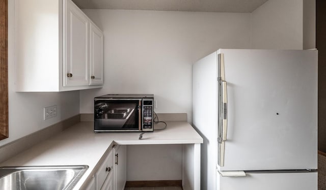 705 Grundhoefer Ct, Northfield, MN 55057 - kitchen featuring freestanding refrigerator, black microwave, white cabinetry, light countertops, and a desk