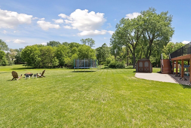 6600 18th St, Saint Louis Park, MN 55426 - view of green lawn with stairs, a trampoline, a fire pit, and a patio
