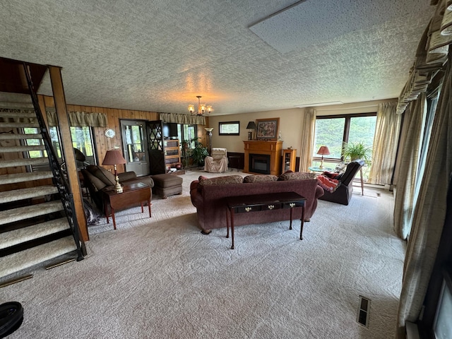 22560 Height Of Land Dr, Detroit Lakes, MN 56501 - carpeted living room featuring a chandelier, a textured ceiling, a fireplace, and stairway