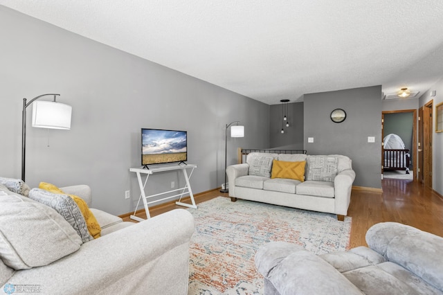 3003 15th Ave S, Moorhead, MN 56560 - living room featuring wood finished floors, baseboards, and a textured ceiling