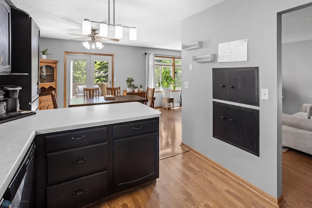 3003 15th Ave S, Moorhead, MN 56560 - kitchen featuring a peninsula, ceiling fan, light wood-style flooring, light countertops, and a textured ceiling