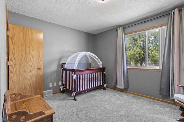 3003 15th Ave S, Moorhead, MN 56560 - carpeted bedroom with a textured ceiling, baseboards, and a nursery area
