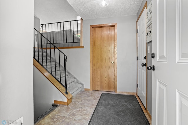 3003 15th Ave S, Moorhead, MN 56560 - entryway with a textured ceiling, stairway, and baseboards