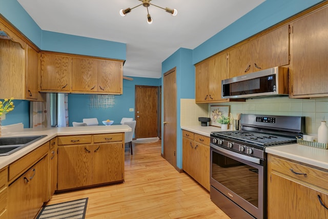 5843 Fairway Ln, Saint Cloud, MN 56303 - kitchen featuring appliances with stainless steel finishes, light countertops, backsplash, and light wood finished floors