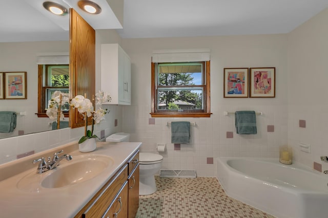 5843 Fairway Ln, Saint Cloud, MN 56303 - bathroom with tile walls, vanity, toilet, a garden tub, and tile patterned floors