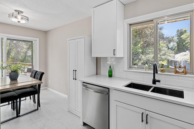 2613 107th Ln NW, Coon Rapids, MN 55433 - kitchen featuring stainless steel dishwasher, light marble finish flooring, tasteful backsplash, white cabinets, and a textured ceiling