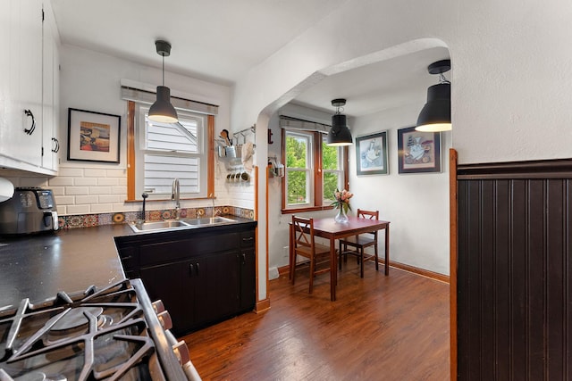 41 17th Ave N, Hopkins, MN 55343 - kitchen with a sink, dark countertops, dark wood-type flooring, backsplash, and pendant lighting