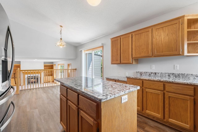 10779 57th St NE, Albertville, MN 55301 - kitchen featuring light wood-style flooring, a kitchen island, open shelves, vaulted ceiling, and a chandelier