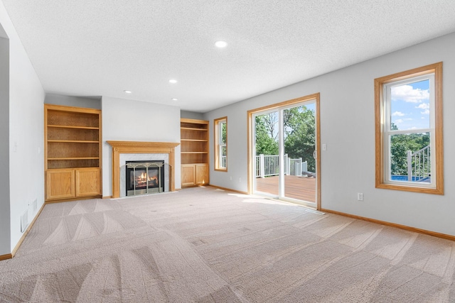 10779 57th St NE, Albertville, MN 55301 - unfurnished living room featuring a textured ceiling, light carpet, a high end fireplace, and recessed lighting