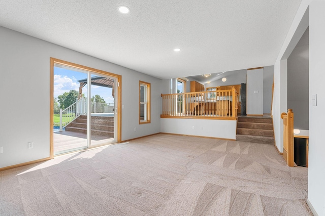 10779 57th St NE, Albertville, MN 55301 - unfurnished living room featuring a textured ceiling, carpet, recessed lighting, and stairs