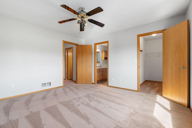 10779 57th St NE, Albertville, MN 55301 - unfurnished bedroom featuring light carpet, a walk in closet, ensuite bath, and a closet