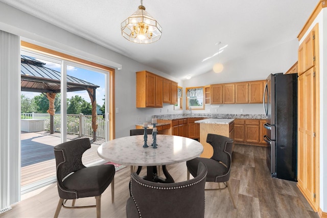 10779 57th St NE, Albertville, MN 55301 - kitchen featuring freestanding refrigerator, a center island, wood finished floors, a chandelier, and vaulted ceiling
