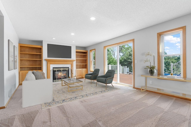 10779 57th St NE, Albertville, MN 55301 - living area featuring a textured ceiling, recessed lighting, a high end fireplace, carpet flooring, and built in shelves