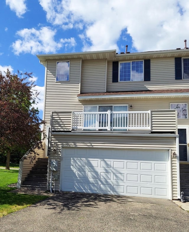 4961 Grenwich Ave N, Oakdale, MN 55128 - view of front of house with a garage, driveway, stairs, and a balcony