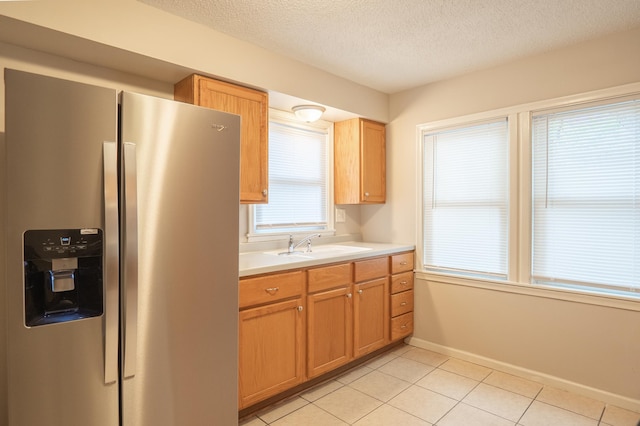 922 Minnehaha Ave E, Saint Paul, MN 55106 - kitchen with stainless steel fridge, light countertops, a sink, a textured ceiling, and light tile patterned floors