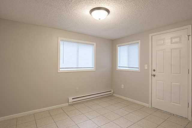 922 Minnehaha Ave E, Saint Paul, MN 55106 - empty room featuring baseboard heating, a textured ceiling, light tile patterned flooring, and baseboards