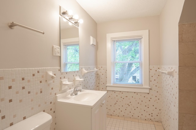 922 Minnehaha Ave E, Saint Paul, MN 55106 - half bath with tile walls, toilet, tile patterned flooring, wainscoting, and vanity