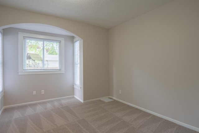 922 Minnehaha Ave E, Saint Paul, MN 55106 - spare room with light colored carpet, arched walkways, baseboards, and a textured ceiling