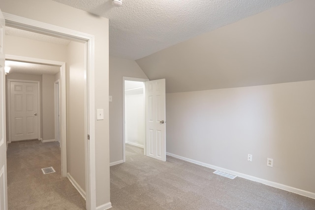 922 Minnehaha Ave E, Saint Paul, MN 55106 - additional living space with light carpet, a textured ceiling, lofted ceiling, and baseboards