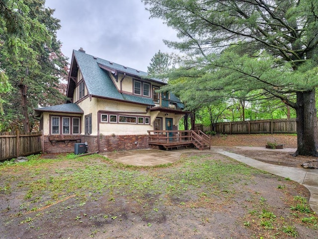 1715 Bush Ave, Saint Paul, MN 55106 - rear view of property with a fenced backyard, central air condition unit, a deck, stucco siding, and a chimney
