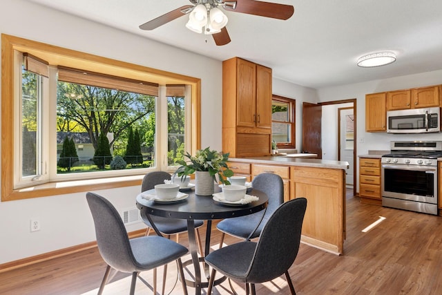 11124 Welcome Ave N, Champlin, MN 55316 - dining area featuring light wood-type flooring, ceiling fan, and baseboards