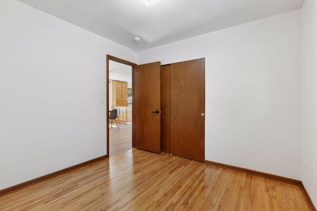 11124 Welcome Ave N, Champlin, MN 55316 - unfurnished room featuring light wood-style floors, baseboards, and a textured ceiling
