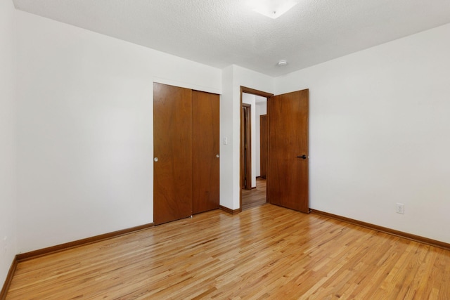 11124 Welcome Ave N, Champlin, MN 55316 - spare room with light wood-type flooring, baseboards, and a textured ceiling