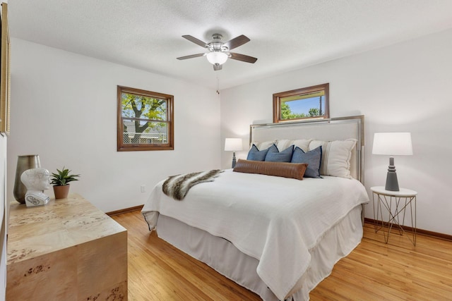 11124 Welcome Ave N, Champlin, MN 55316 - bedroom featuring multiple windows, light wood finished floors, baseboards, and a textured ceiling