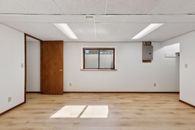 11124 Welcome Ave N, Champlin, MN 55316 - empty room featuring electric panel, a paneled ceiling, light wood-style flooring, and baseboards