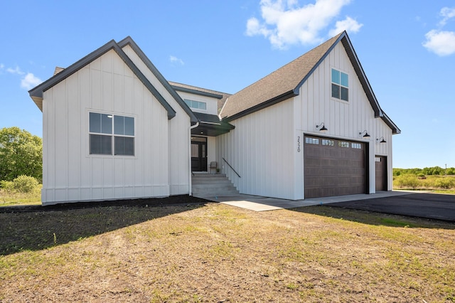 2520 230th Ct NW, Saint Francis, MN 55070 - modern farmhouse with board and batten siding, a garage, roof with shingles, asphalt driveway, and a front lawn