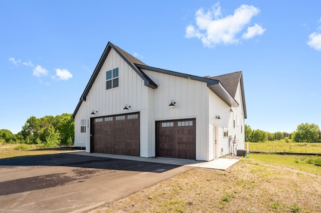 2520 230th Ct NW, Saint Francis, MN 55070 - view of front of property with board and batten siding, roof with shingles, asphalt driveway, and central air condition unit