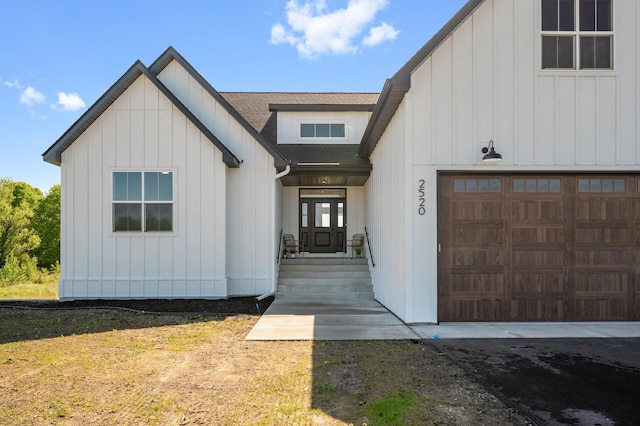 2520 230th Ct NW, Saint Francis, MN 55070 - view of exterior entry with a garage, board and batten siding, and roof with shingles