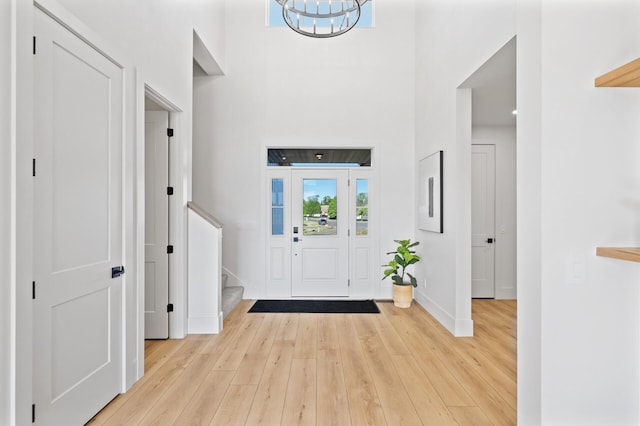 2520 230th Ct NW, Saint Francis, MN 55070 - foyer entrance featuring a chandelier, stairway, wood-type flooring, a towering ceiling, and baseboards