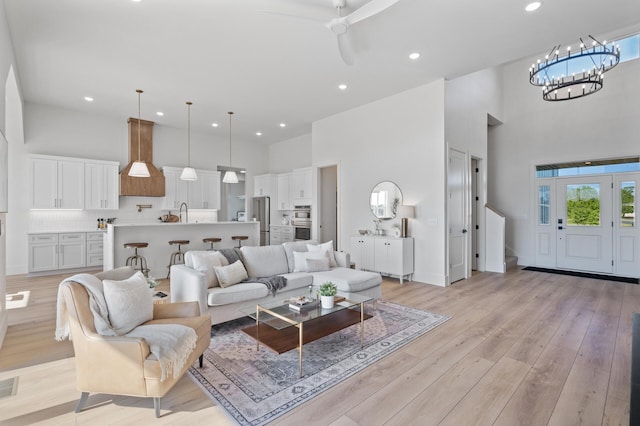 2520 230th Ct NW, Saint Francis, MN 55070 - living room featuring a towering ceiling, a chandelier, recessed lighting, light wood finished floors, and ceiling fan