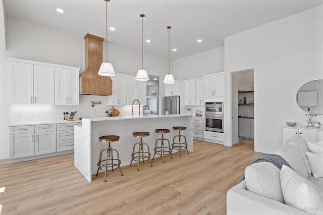 2520 230th Ct NW, Saint Francis, MN 55070 - kitchen featuring appliances with stainless steel finishes, open floor plan, a towering ceiling, a kitchen bar, and premium range hood