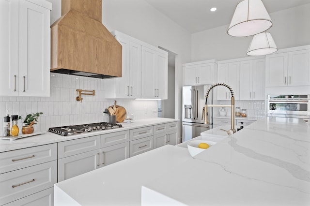 2520 230th Ct NW, Saint Francis, MN 55070 - kitchen with custom exhaust hood, stainless steel gas stovetop, backsplash, white cabinetry, and hanging light fixtures