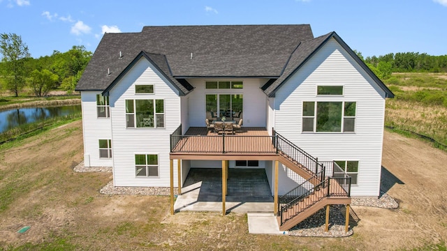 2520 230th Ct NW, Saint Francis, MN 55070 - back of property with stairs, roof with shingles, a deck with water view, a patio area, and dirt driveway
