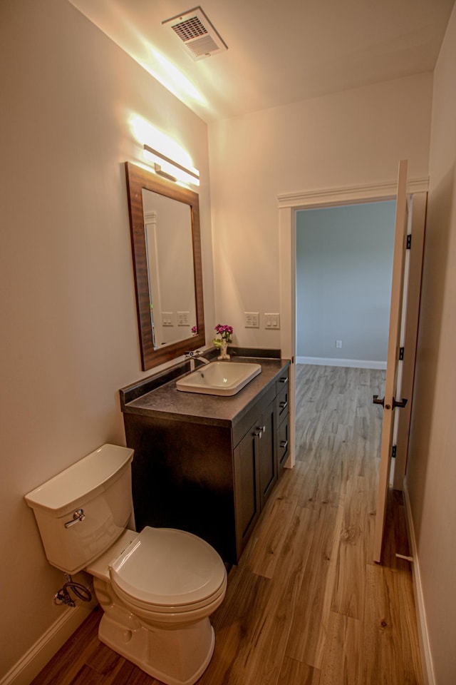 850 60th Ave SW, Benson, MN 56231 - half bath featuring wood finished floors, toilet, vanity, and baseboards