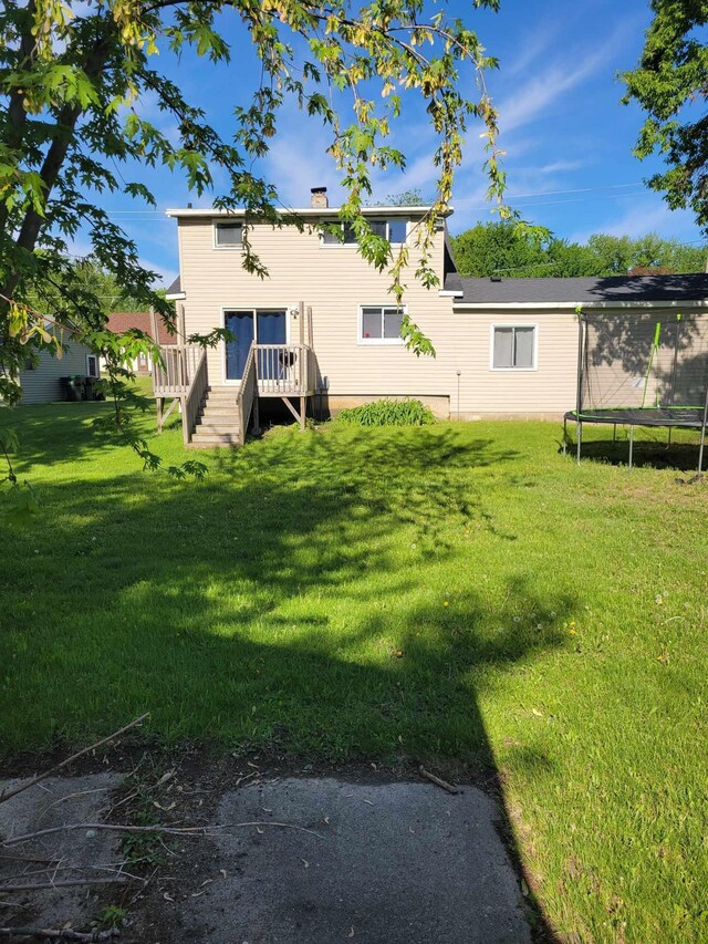 640 6th St, Albany, MN 56307 - back of house with a trampoline, a lawn, a chimney, and a deck