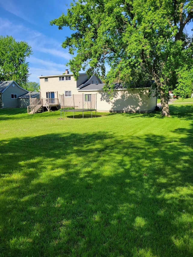640 6th St, Albany, MN 56307 - view of grassy yard with a trampoline, a deck, and stairway