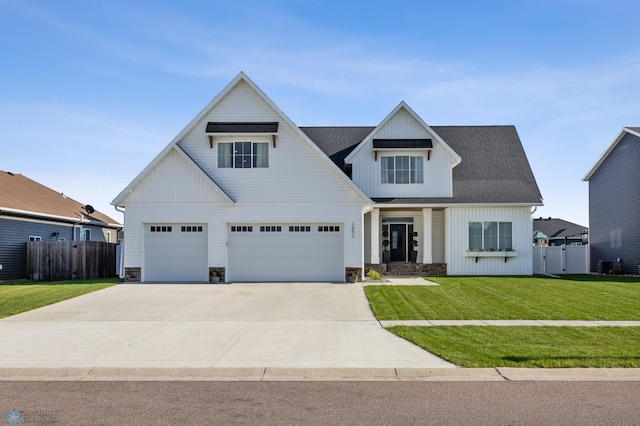 2652 70th Ave S, Fargo, ND 58104 - modern farmhouse with driveway, a garage, board and batten siding, stone siding, and roof with shingles