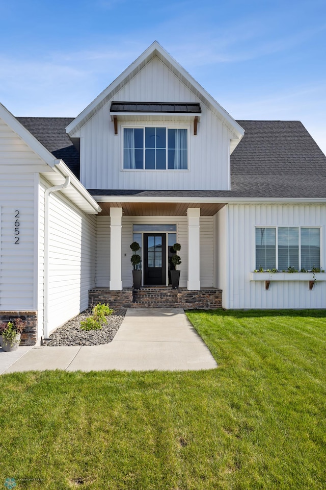 2652 70th Ave S, Fargo, ND 58104 - modern farmhouse featuring board and batten siding, a shingled roof, a front yard, and covered porch
