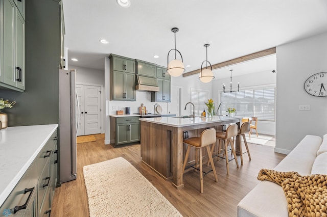 2652 70th Ave S, Fargo, ND 58104 - kitchen with green cabinets, a sink, freestanding refrigerator, ventilation hood, and light countertops
