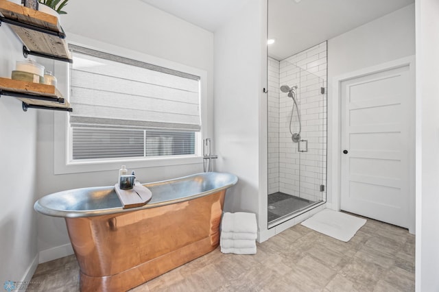 2652 70th Ave S, Fargo, ND 58104 - bathroom featuring a shower stall, a soaking tub, and baseboards