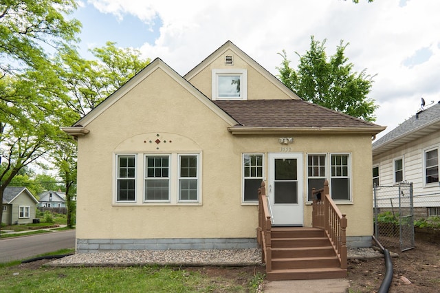 3550 Bryant Ave N, Minneapolis, MN 55412 - view of front of property with stucco siding, a shingled roof, and entry steps