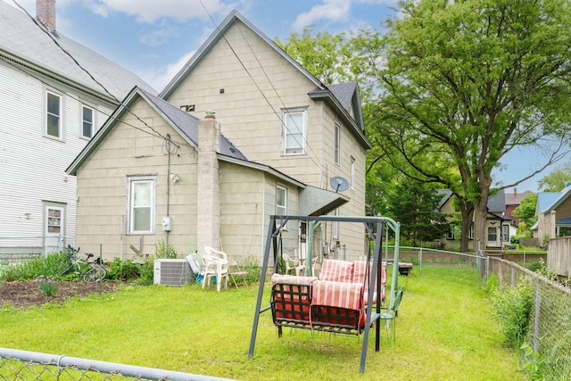 310 Burgess St, Saint Paul, MN 55117 - rear view of property featuring a shingled roof, central AC, and a chimney