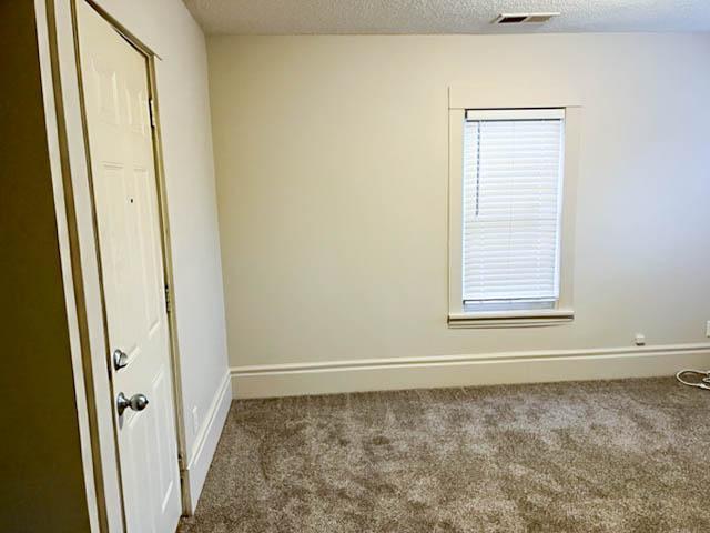 310 Burgess St, Saint Paul, MN 55117 - unfurnished bedroom featuring carpet floors, baseboards, and a textured ceiling